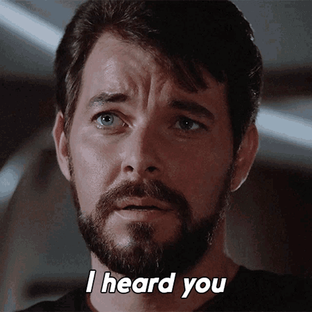 a man with a beard says " i heard you " in front of his face