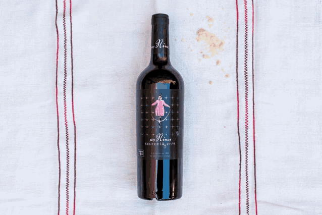 a bottle of wine with a woman on the label is sitting on a table