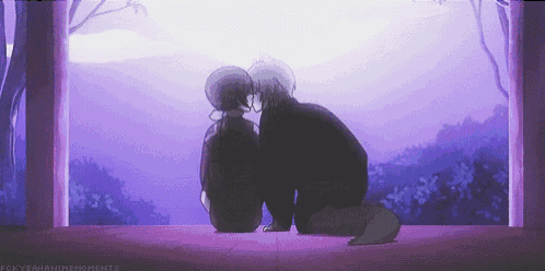 a man and a woman are sitting next to each other and kissing in front of a purple sky .