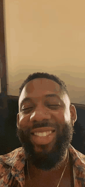 a man with a beard and nose ring is smiling