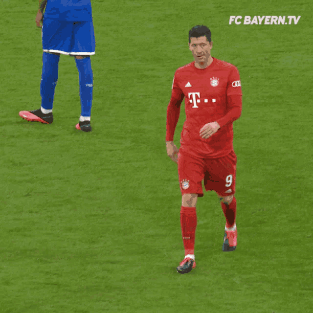 a man in a red t-mobile jersey stands on a soccer field