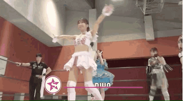 a woman in a white dress is standing in a wrestling ring with a star and the word niua on it