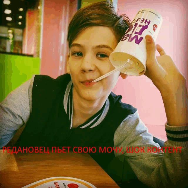 a young boy drinks from a cup that says mcdonald 's on it
