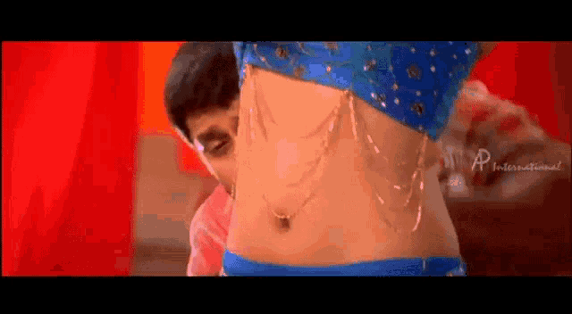 a man is looking at a woman 's stomach in a blue top .