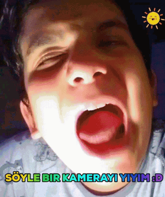 a boy with his mouth open and the words sayle bir kamerayi yiyim : d below him