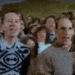 a group of people are sitting in a stadium watching a game and laughing .