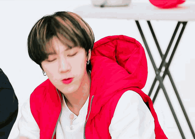 a man wearing a red vest with a hood