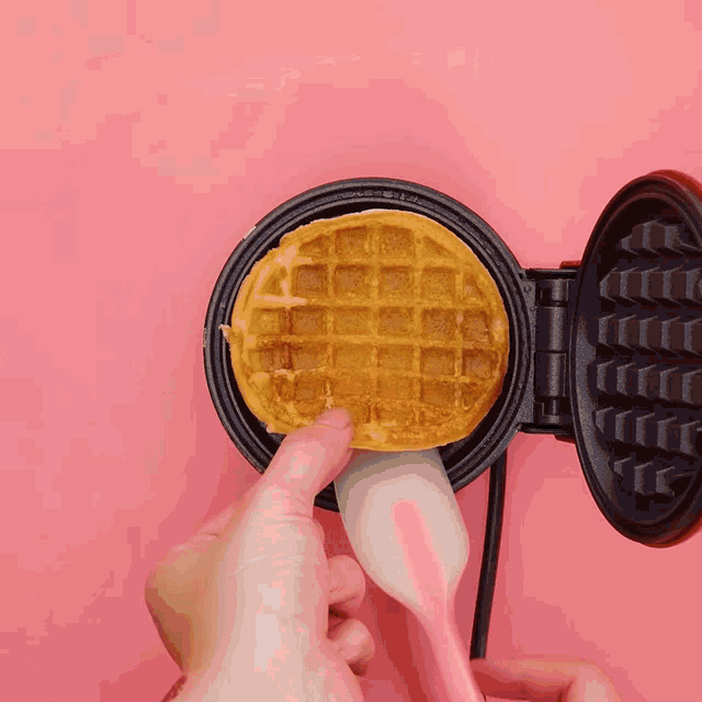 a waffle is being decorated with icing and the word cream is above it