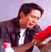 a man is sitting at a table looking at a red object .