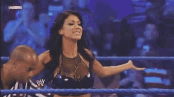 a woman in a wrestling ring with a w logo on the bottom right corner