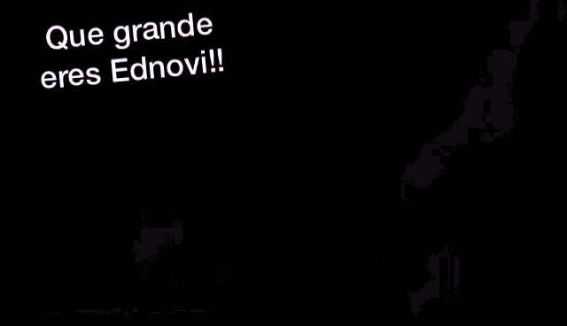 a man stands on a stage with a sign that says que grande eres ednovi on it