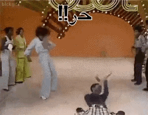 a group of people are dancing in front of a sign that says ' !! '