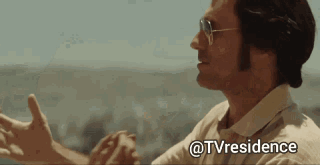 a man wearing sunglasses and a white shirt with the words @tvresidence on the bottom right