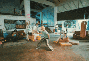 a group of people are gathered in a room with graffiti on the walls including one that says ' i love you '