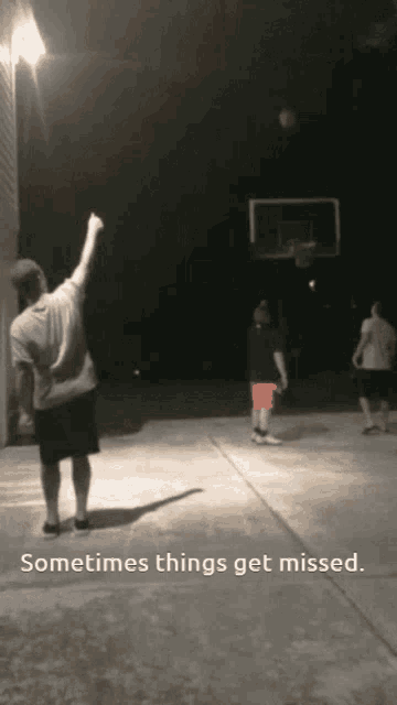 a group of people are playing basketball in a driveway at night and the caption says sometimes things get missed