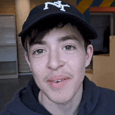 a young man wearing a hat with the letter ny on it