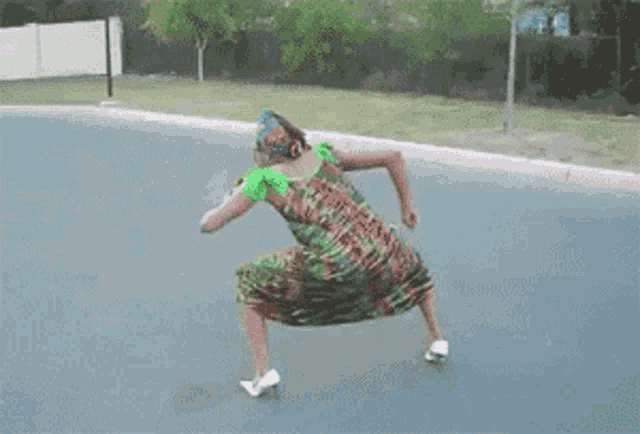 a woman in a colorful dress and heels is dancing on the street