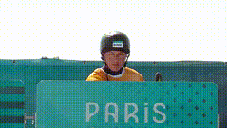 a man wearing a helmet and a yellow shirt is behind a fence that says bras