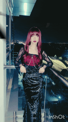 a woman in a black dress is standing on a balcony with inshot written in the corner