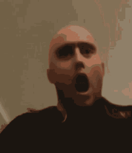 a bald man is making a surprised face with his mouth wide open