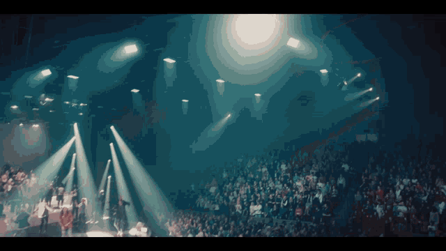 a crowd of people are watching a concert with a lot of lights