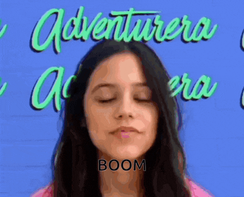 a woman with her eyes closed says boom in front of a sign that says adventurera