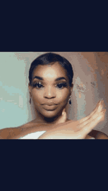 a woman with short hair and earrings is making a face