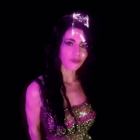 a close up of a woman 's face with a purple light shining on it .