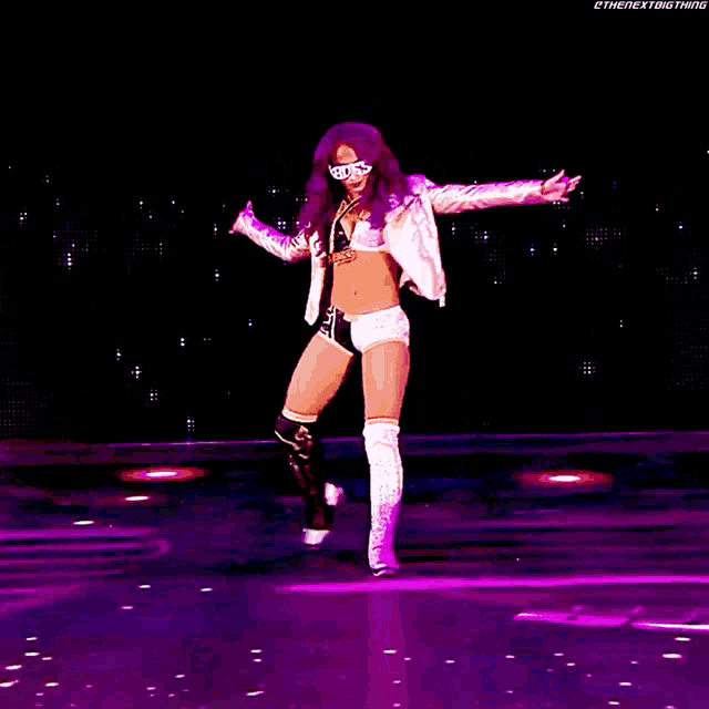 a woman with purple hair is dancing on a stage with the words the next big thing on the bottom