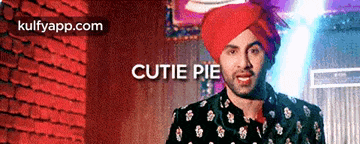 a man wearing a turban with the words cutie pie on it