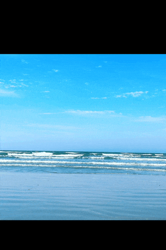 a beach with a blue sky and white clouds