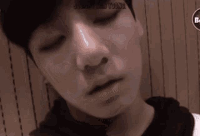 a close up of a boy 's face with his eyes closed