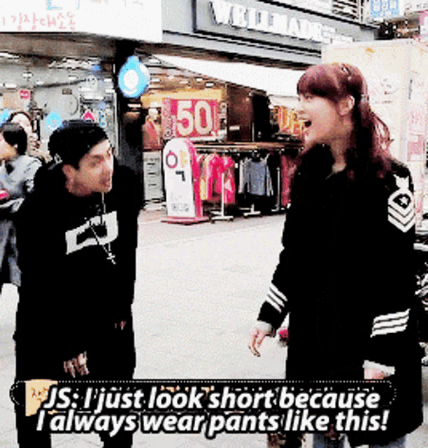 a man and a woman are standing in front of a store with a sign that says 50 off