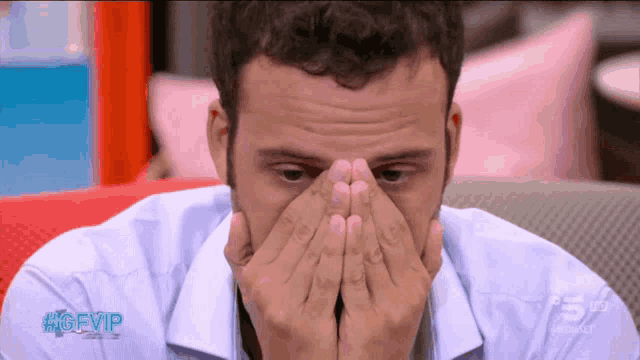 a man covering his face with his hands with the hashtag #gfvip on the bottom right