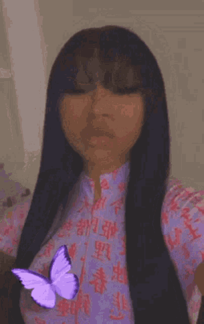 a woman with long black hair is taking a selfie with a butterfly on her face .