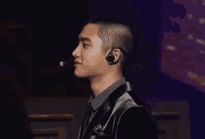 a man in a suit and tie is wearing a microphone and earphones .