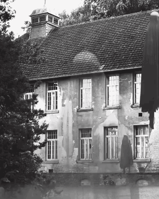 a black and white photo of an old building with a roof