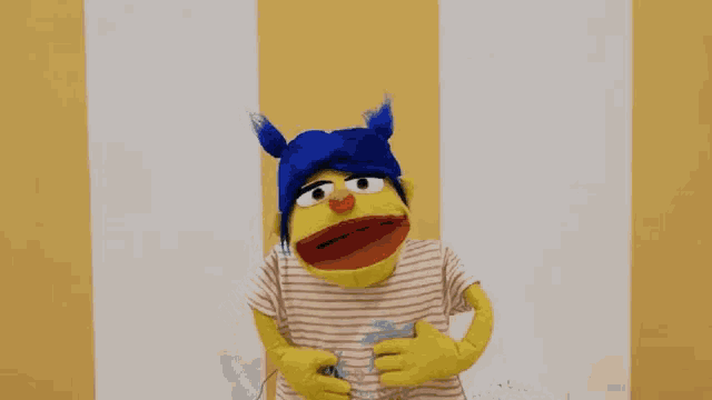 a puppet wearing a blue hat and striped shirt