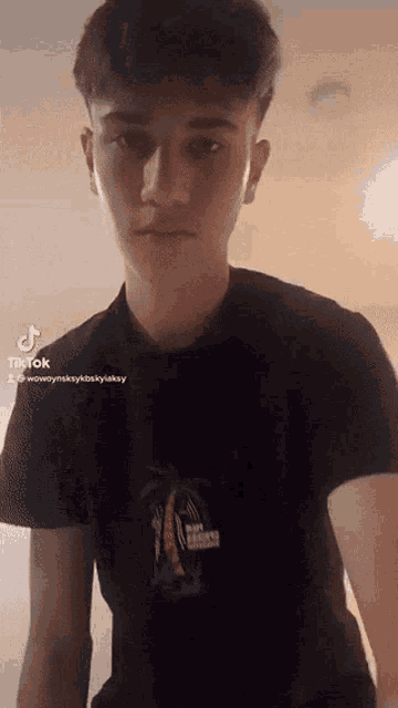 a young man is wearing a black t-shirt with a palm tree on the front