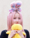a woman wearing a pink hat and a pink poncho is making a face .