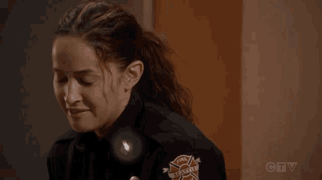 a woman in a firefighter uniform is laughing in front of a door with the number 07 on it