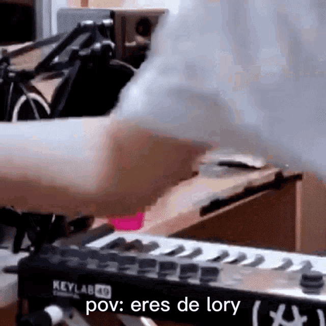 a person is playing a keyboard with the words pov : eres de lory written on it