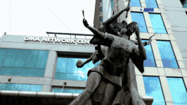 the gma network center has a statue in front of it