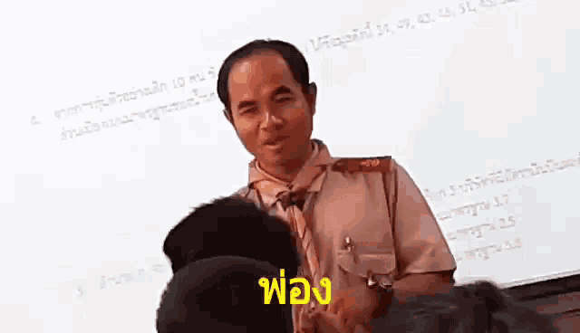 a man in a military uniform is talking to a group of people in front of a white board .