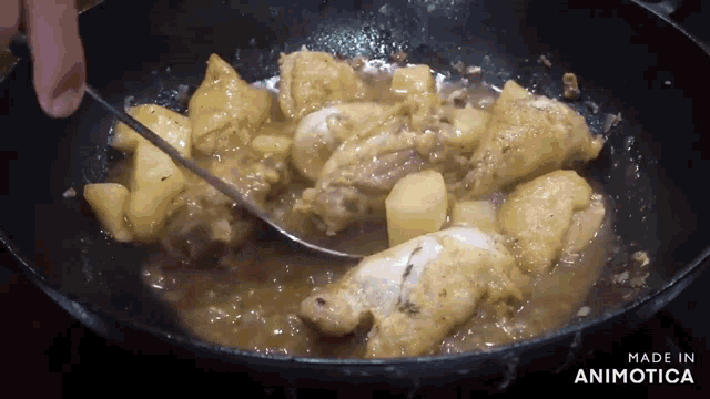chicken and potatoes are being cooked in a pan with the words made in animotica visible