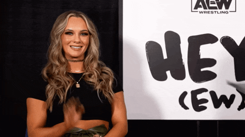 a woman standing in front of a sign that says hey