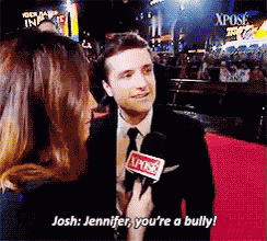 a man in a suit and tie is being interviewed by a woman with the words josh jennifer you 're a bully