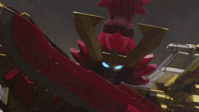 a toy robot with a red and gold helmet holds a sword