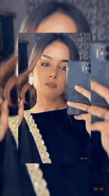 a woman is taking a selfie in front of a mirror .