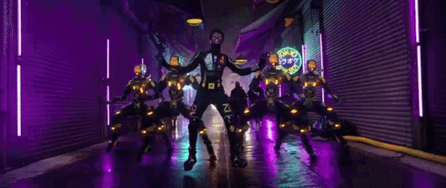 a man is standing in front of a bunch of robots and a sign that says karaoke